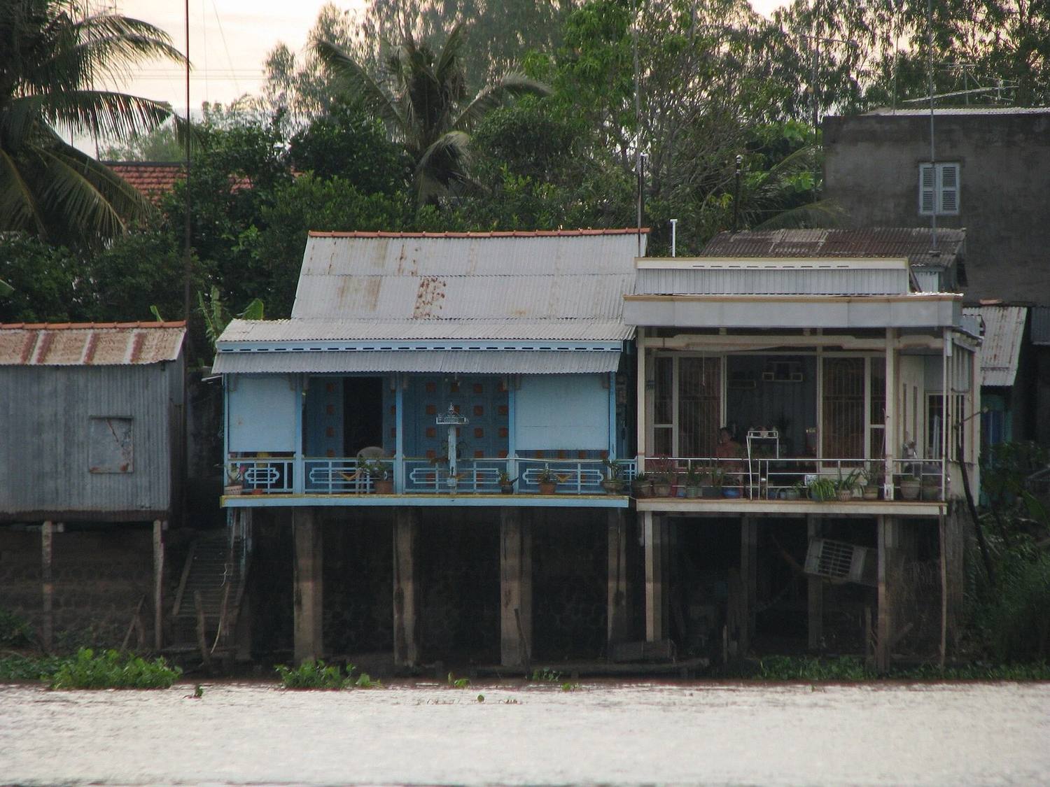 Riverside houses on stilts along a Mekong Delta waterway